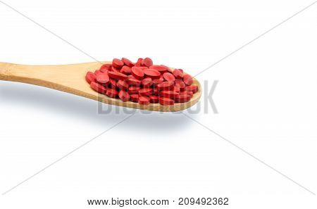 Iron tablets in spoon isolated on white background with copy space for text and clipping path. Use for topics about treatment anemia in adult elderly people and children. Blood donations concept.