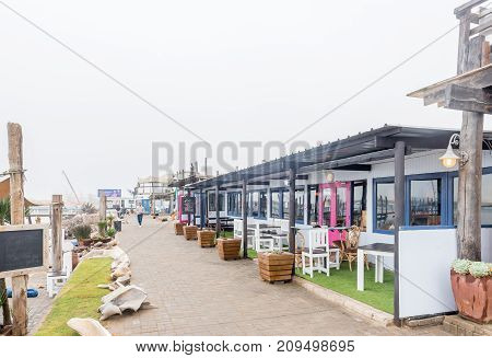 WALVIS BAY NAMIBIA - JULY 1 2017: A restaurant and other businesses at the watefront in Walvis Bay on the Atlantic Coast of Namibia