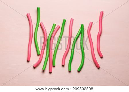 hair curlers isolated on light pink background. Top view flat lay composition for articles, magazines, bloggers, designers etc.