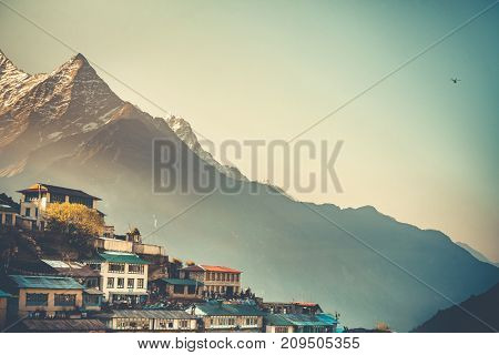 Sunrise view of Namche Bazaar village and Thamserku mountain, Khumbu valley, Nepal. Trekking route to Everest Base Camp, Himalayas. Travel background. Beautiful nature landscape. Retro vintage toning