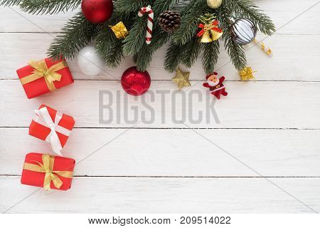 Christmas background - Christmas present red gifts box and fir leaves with decorative elements on white wooden background. Creative flat lay top view design