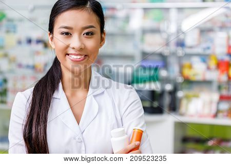 Pharmacist With Medication In Drugstore