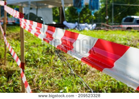 Red and white tripped tape fence for barricades or murder zones or crime scene.