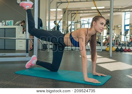 Sporty young girl doing yoga in a fitness room