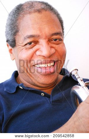 African american jazz musician expressions with his flugelhorn indoors.