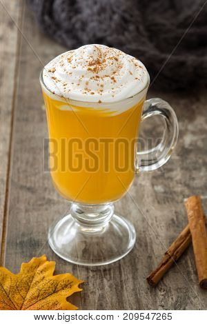 Pumpkin spiced latte on wooden table. Typica halloween drink