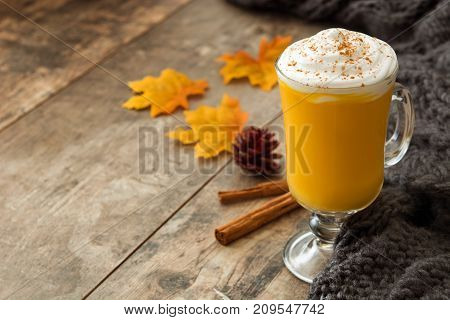 Pumpkin spiced latte on wooden table. Typica halloween drink