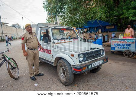 DELHI, INDIA - SEPTEMBER 25, 2017: A traffic policeman controling the traffic in Chandi Chowk area of the city. Traffic congestion is common in India's towns and cities.