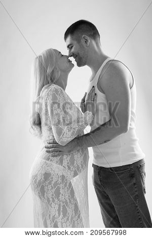 Beautiful pregnant couple in love on the background. Hands of husband on the tummy of his pregnant wife. Young man tenderly stroked pregnant belly of his wife. Husband kissing pregnant belly.