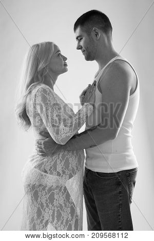 Beautiful pregnant couple in love on the background. Hands of husband on the tummy of his pregnant wife. Young man tenderly stroked pregnant belly of his wife. Husband kissing pregnant belly.