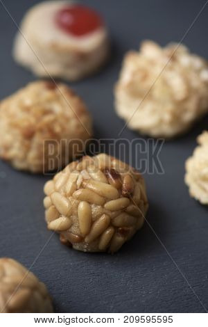 closeup of some panellets, typical confection eaten in All Saints Day in Catalonia, Spain, on a dark gray surface