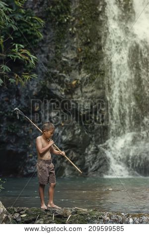 rural children are fishing at the river at forestChildren poverty living in countryside Vietnam are fishing at the river.
