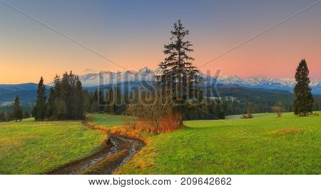Morning in green valley. Green valley on snowy mountains background in dawn. Famous touristik place in Poland Zakopane.