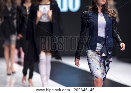 Sofia, Bulgaria - 28 September, 2017: Female models walk the runway in different dresses during a Fashion Show. Fashion catwalk event showing new collection of clothes. In a row.
