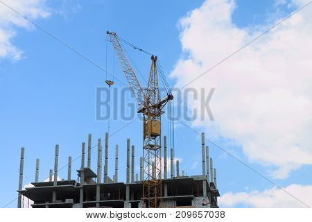 Stationary hoist on construction site part of building blue sky and white clouds