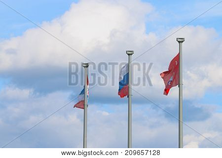 Three flags on poles and sky - flag of Russia flag of Perm city and Permsky krai