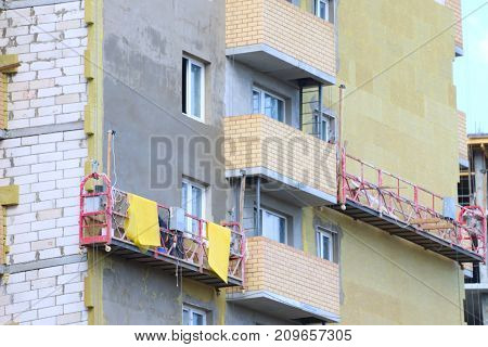 Suspended cradle for worker for facing facade of tall building under construction