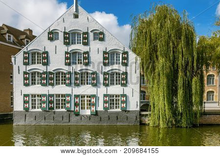 A white building and Willow tree by the river Nete in Lier, Belgium