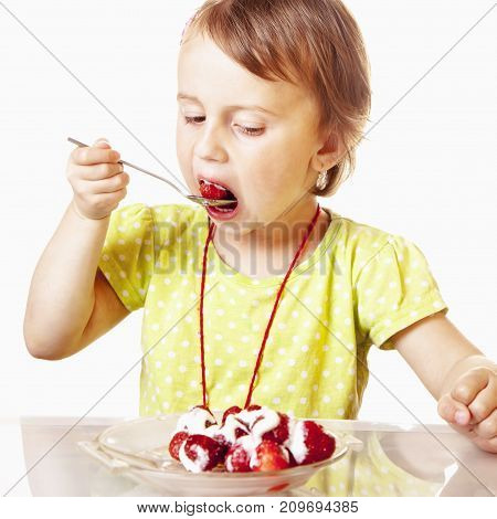 A little beautiful baby girl eating and enjoying of fresh strawberries. (Health Nutrition Vitamins Happy Childhood Concept)