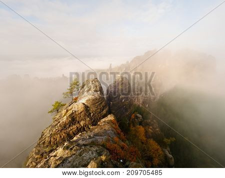 Distant Mountain Range And Heavy Clouds Of Colorful  Mist Above Deep Valleys
