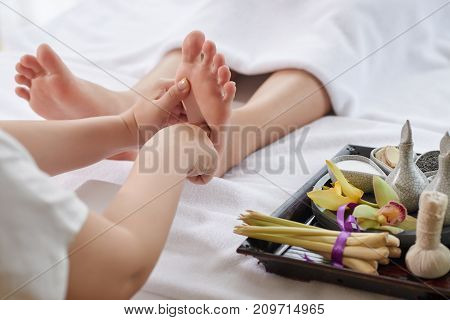 Masseur doing foot massage for female client