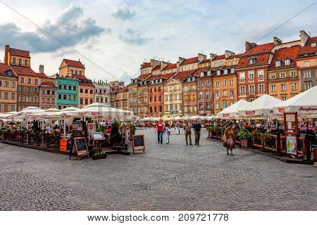WARSAW, POLAND - JUNE, 2012: Beautiful view of Old Town market place on sunny day with lots of tourists
