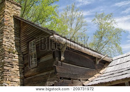 Old cabin with rock chimney and weathered siding