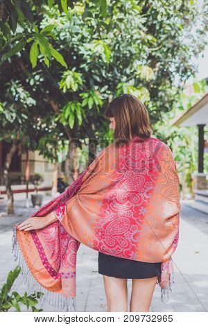Fashionable young woman with cashmere scarf stand outdoor.