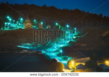 Gori, Shida Kartli Region, Georgia. Road To Sameba Saint Trinity Church In Bright Yellow Evening Illumination In Autumn Twilight.