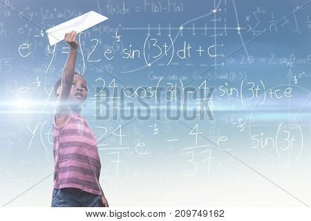 Boy holding paper airplane against blue and yellow sky