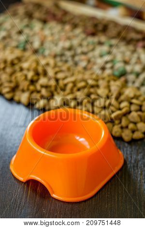 Small orange bowl for pet food and dry food as background