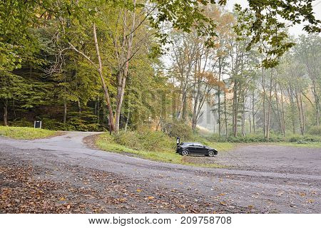 Kokorinsky Dul Czech republic - September 29 2017: Paid parking lot for tourist leading to Kokorin castle with first parked car during foggy sunrise in Kokorinsko landscape area