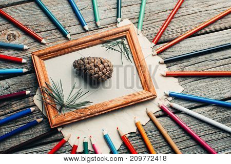 Christmas Composition, Photo Frame On Wooden Table With Tree Branches With Pencils And Cones