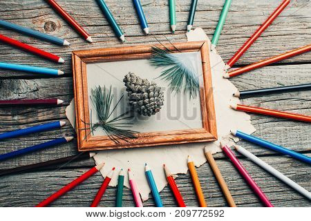 Christmas Composition, Photo Frame On Wooden Table With Tree Branches With Pencils And Cones