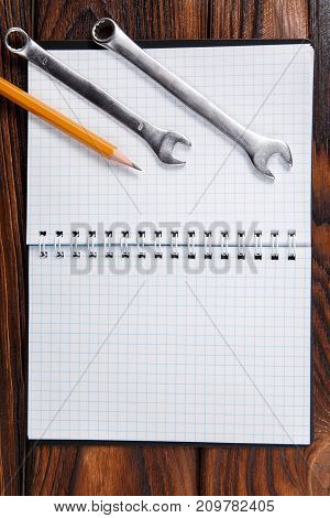 Vertical photo of old hand tools and notepad on wooden table