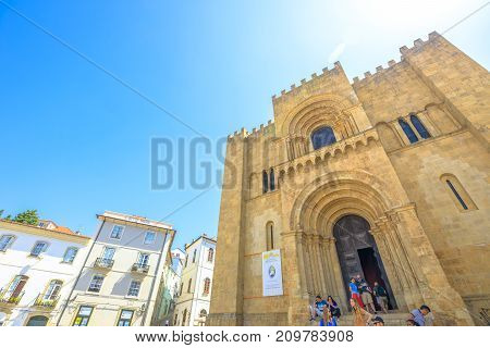 Coimbra, Portugal - August 14, 2017: tourists in front of Old Coimbra Cathedral. Se Velha de Coimbra, is one of most important romanesque buildings in Central Portugal in university town of Coimbra.