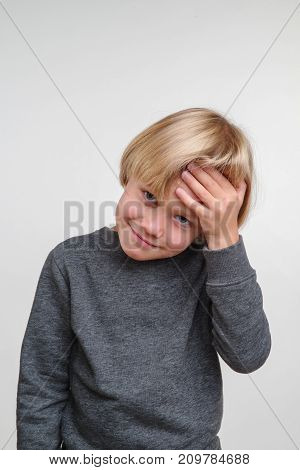 Vertical photo of emotional caucasian boy. Handsome happy child, image on grey background
