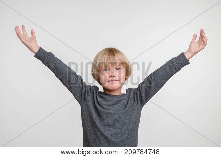 Horisontal emotional portrait of caucasian boy. Handsome happy child, photo on grey background