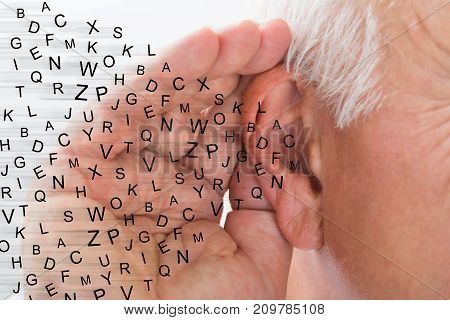 Mature Man Holding Hand Near Ear And Listening Carefully Alphabet Letters Fly