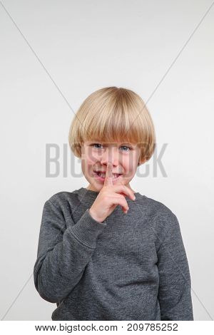 Vertical portrait of handsome happy child, photo on grey background