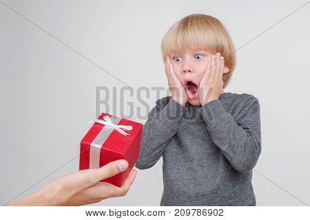 Emotional portrait of caucasian boy isolated on white background vith gift