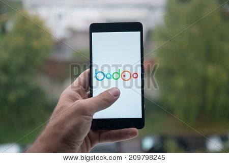 London, United Kingdom, october 3, 2017: Man holding smartphone with Badoo logo with the finger on the screen
