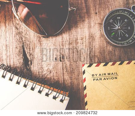 travel concept vintage and modern compass on vintage old paper envolope with note paper and pen