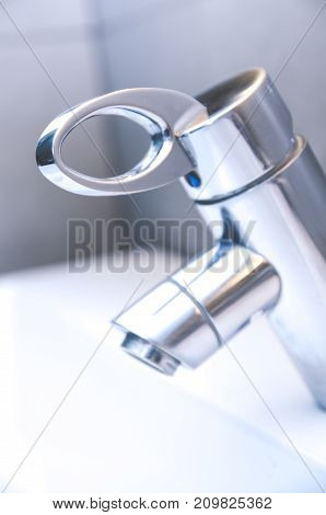Modern faucet closeup with water drop (water tap sink)