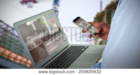 Businessman using 3D mobile phone and laptop against work in progress in the city