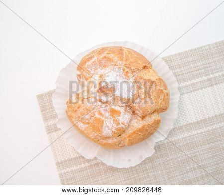 Profiteroles stuffed with pastry cream on white desk in cafe