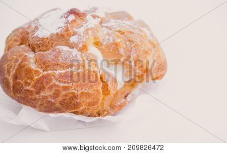 Profiteroles stuffed with pastry cream on white desk in cafe