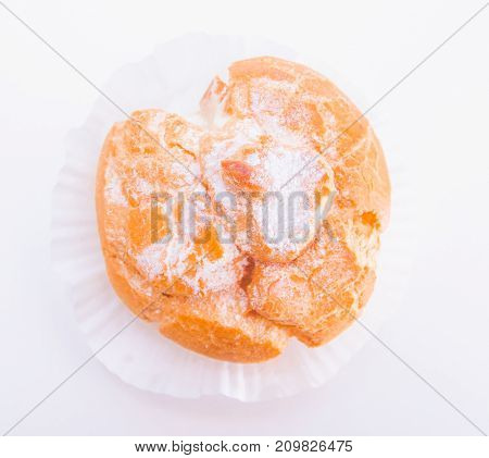 Profiteroles stuffed with pastry cream on white desk in cafe