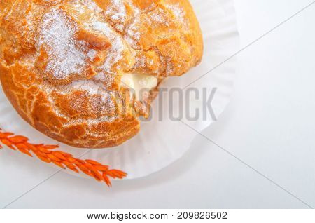 Profiteroles stuffed with pastry cream on white desk in cafe