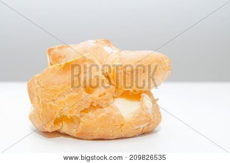 Profiteroles stuffed with pastry cream on white desk in cafe